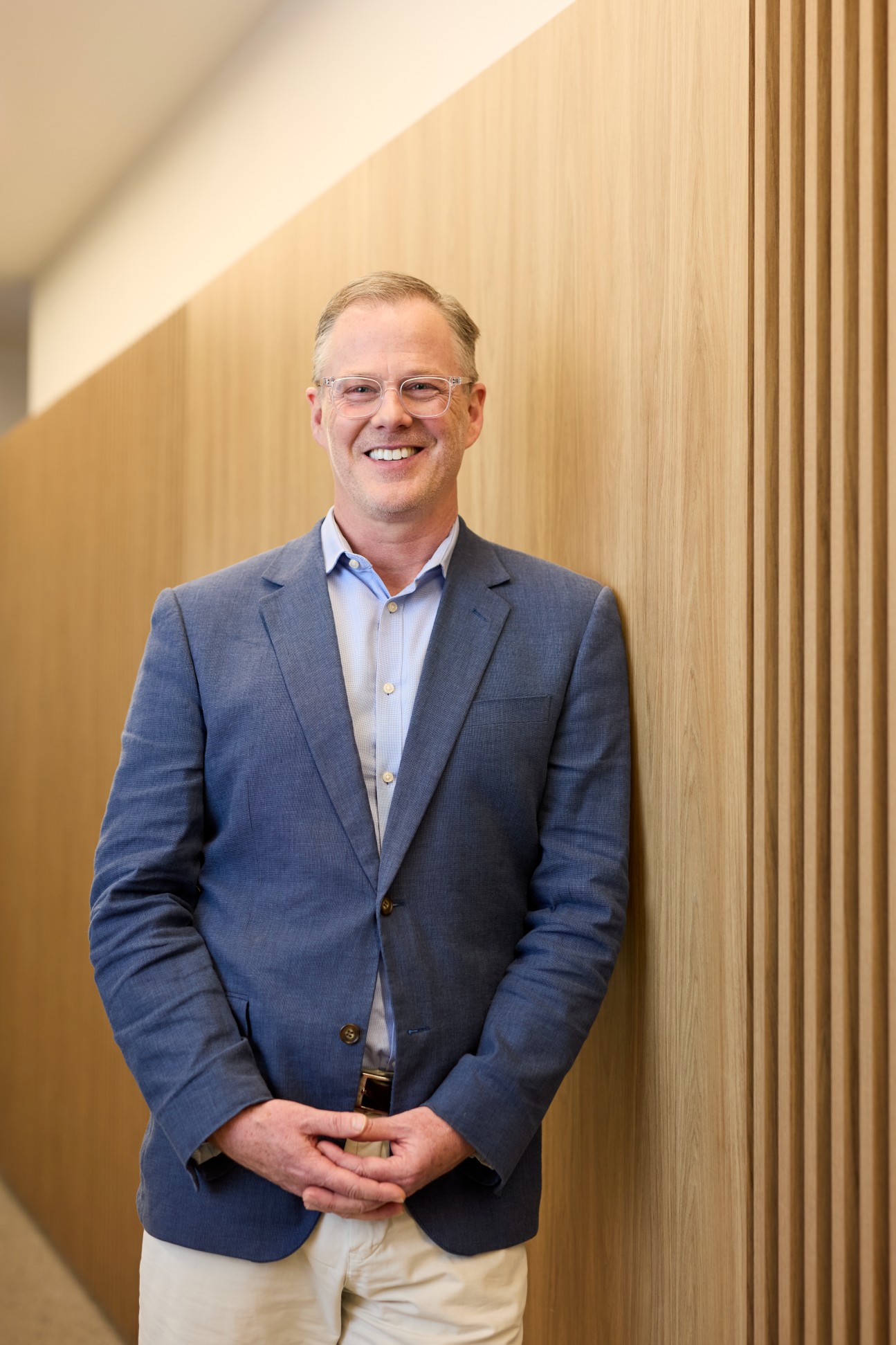 Image of Josh Funder standing against a wooden wall