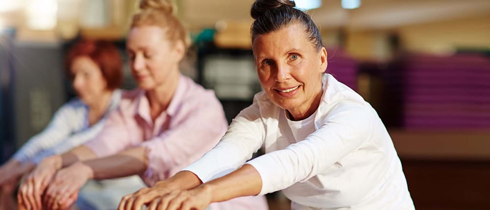 Retiree lady stretching yoga class
