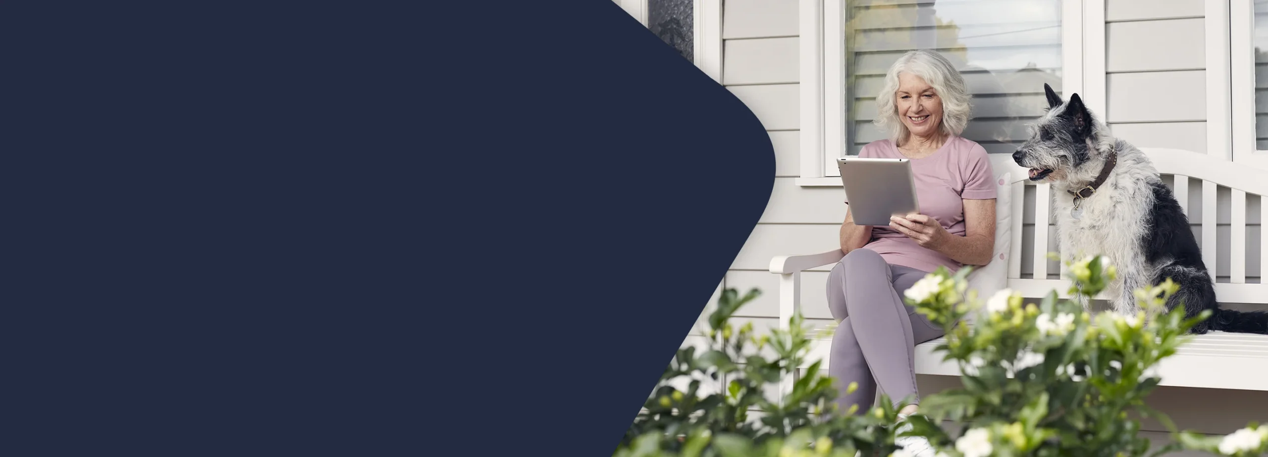 Lady holding iPad sitting next to a dog
