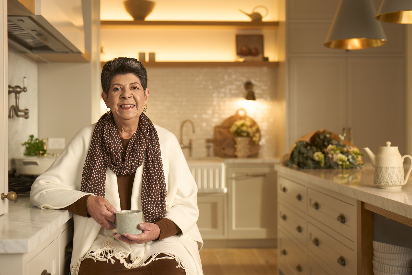 Lady in kitchen holding a cup